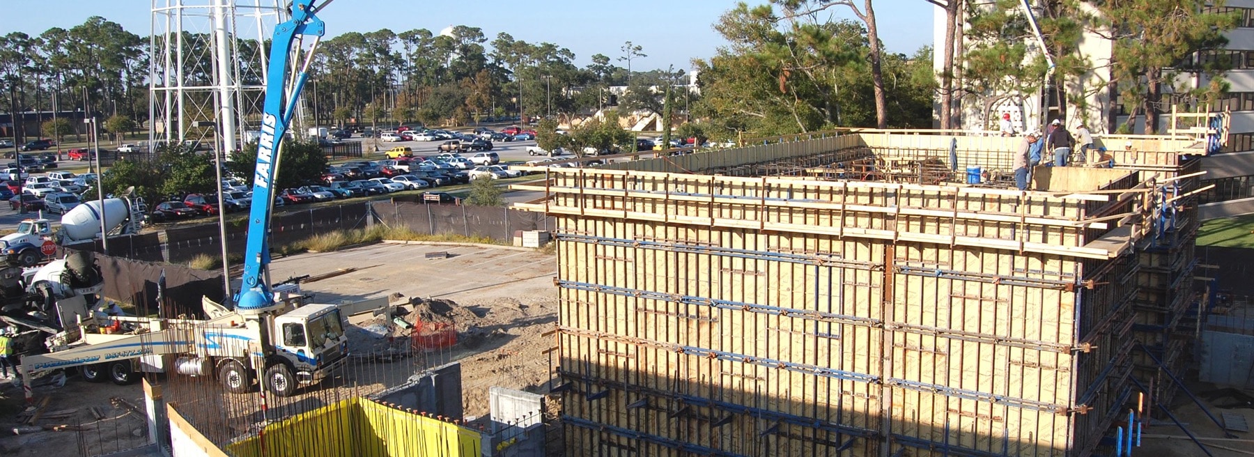Construction crew pouring concrete onsite with a concrete pump truck